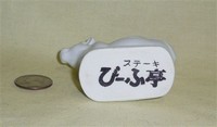 Small white Japanese cow with large hole in butt, bottomn